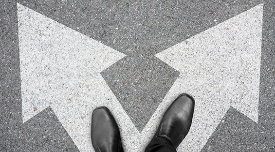 Black Shoes Standing on Decision Arrows